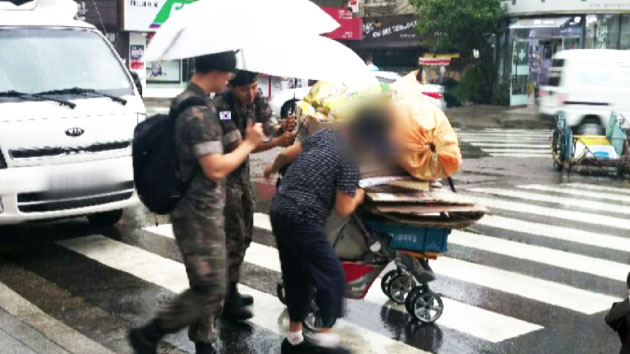 '폐지' 할머니에게 우산이 되어준 훈훈한 병사들