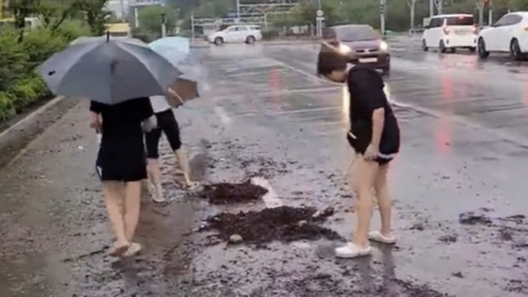“우리 발로 빼자” 폭우 속 우산·슬리퍼로 하수구 뚫은 여중생들