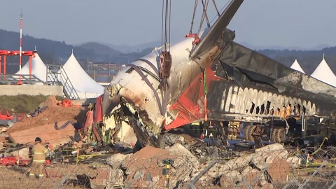 Lift the tail of the airliner to recover the remains and relics.